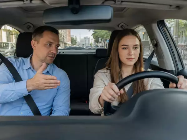 Ученик и инструктор на занятии по вождению в автошколе на категорию B